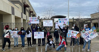 students holding Cereal Box Drive signs